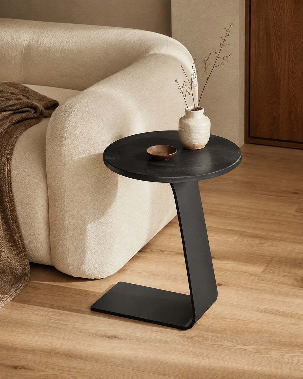 Solid Black Sintered Stone Modern C-Shaped Side Table beside a sofa