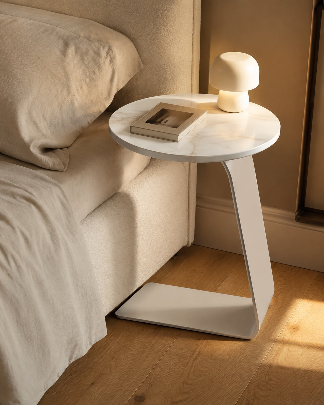 Snow White Sintered Stone Modern C-Shaped Side Table beside a bed